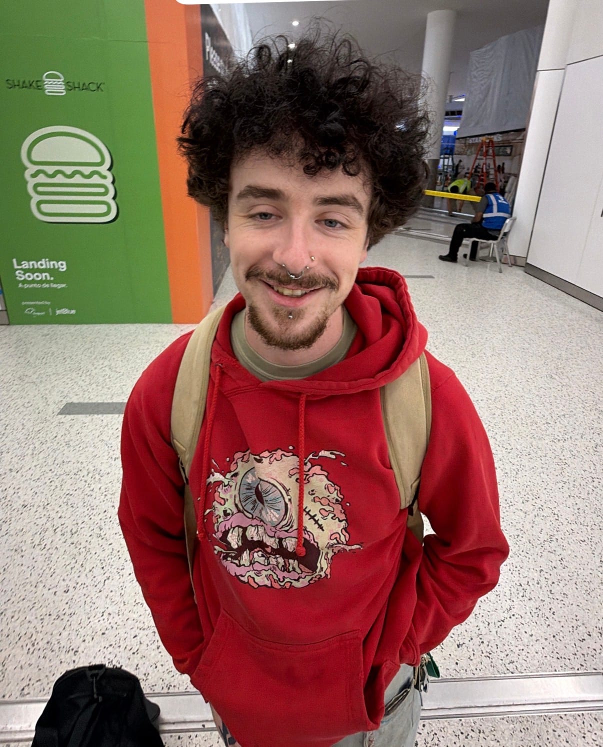 Clay wearing a red hoodie at an airport